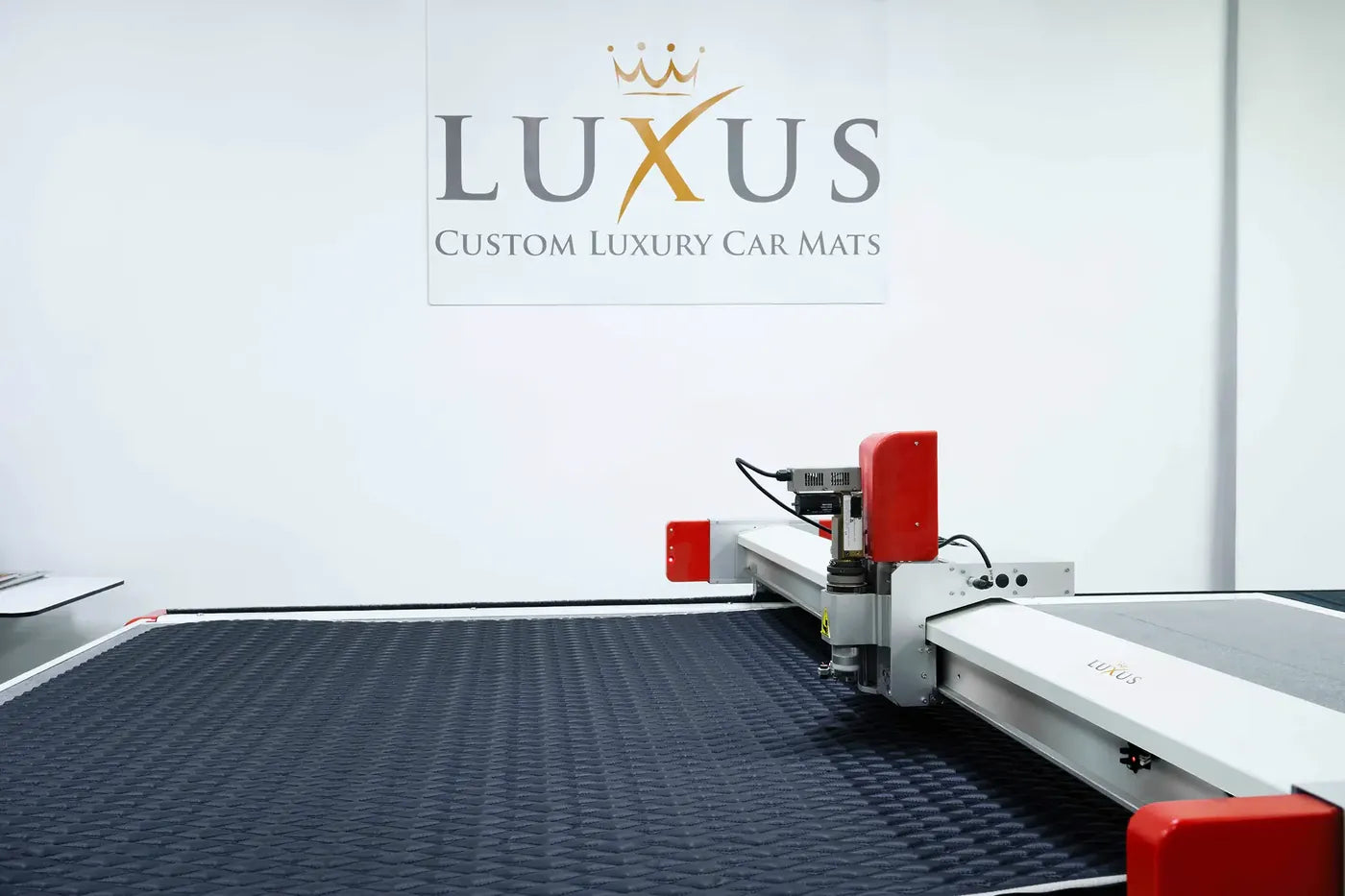 Computer-guided cutting table in the Luxus workshop under the Luxus logo