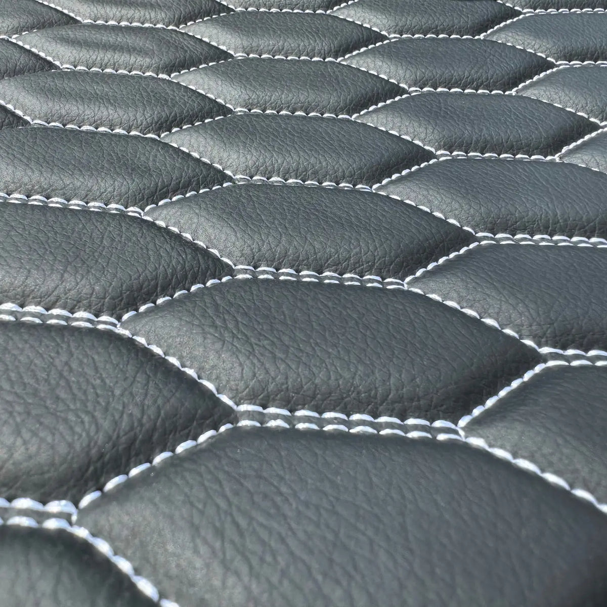 Close-up of Omnicore 14 eco-leather with white honeycomb stitching