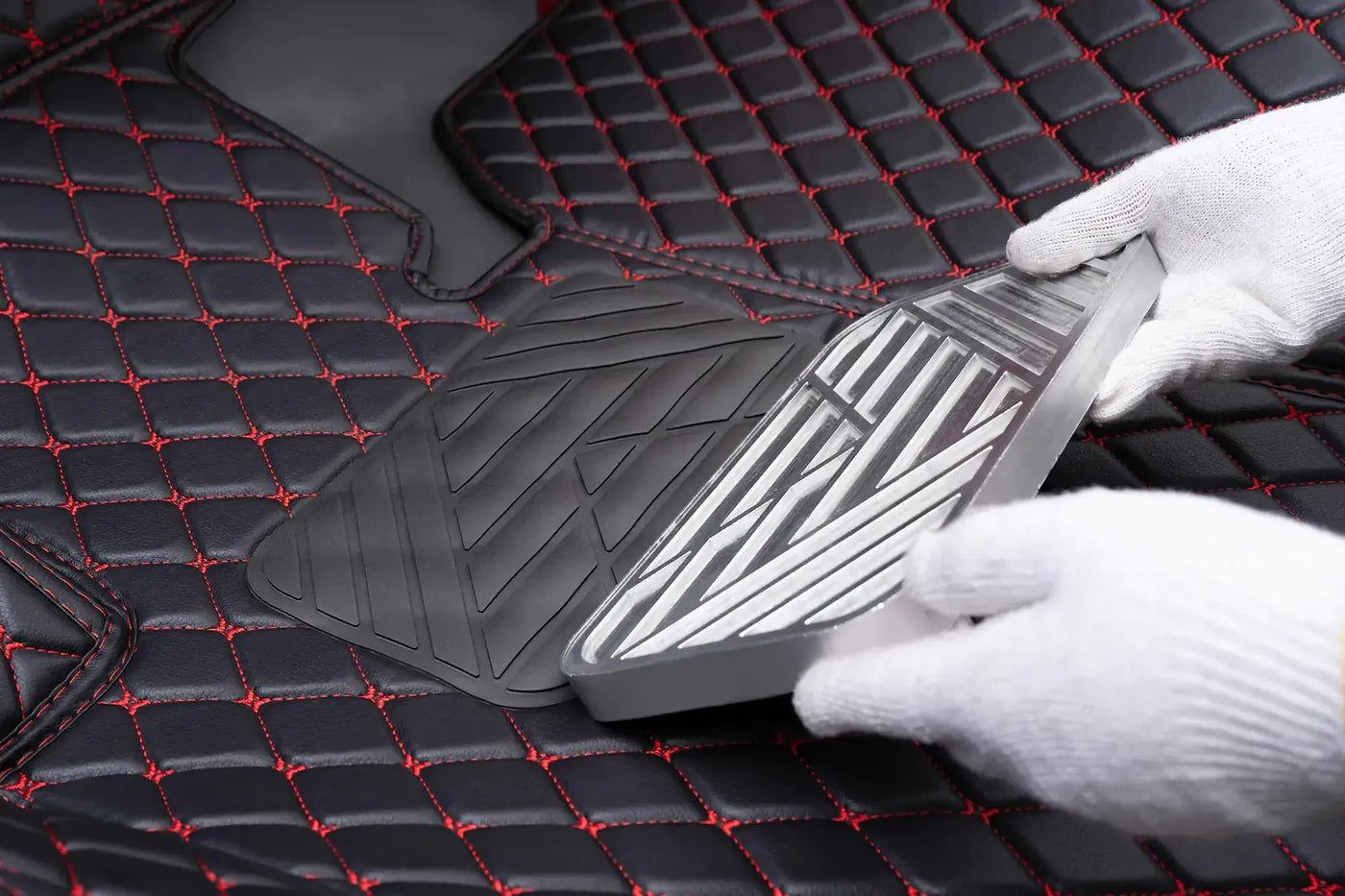 Reinforced heel pad being placed on a black Luxus mat with red stitching