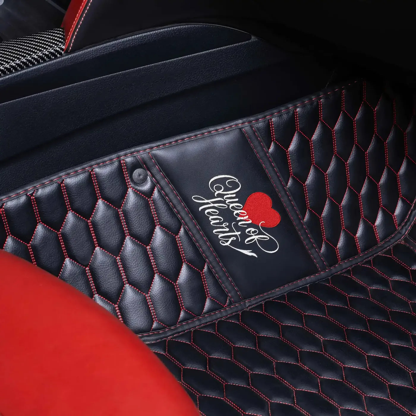 Queen of Hearts text and heart embroidered on a black car mat with red stitching